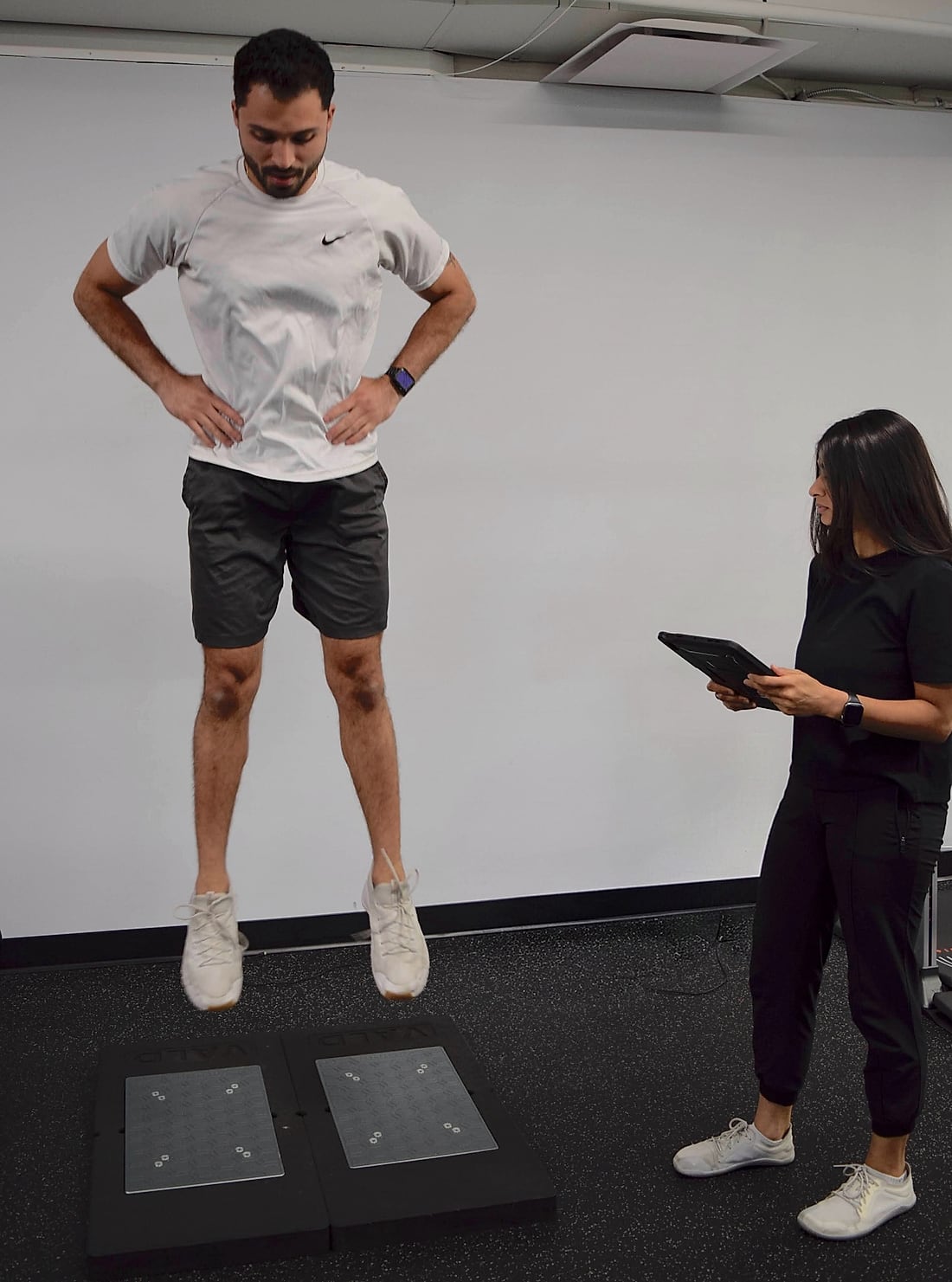 Athlete performing a jump assessment with a coach observing